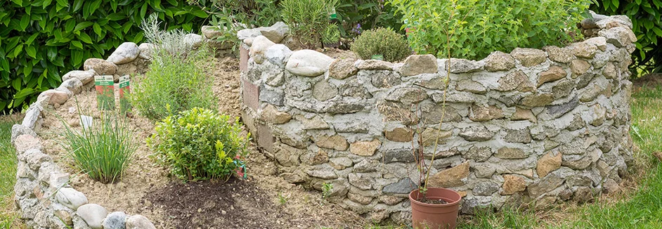 Kräuterspirale aus Steinen im Garten